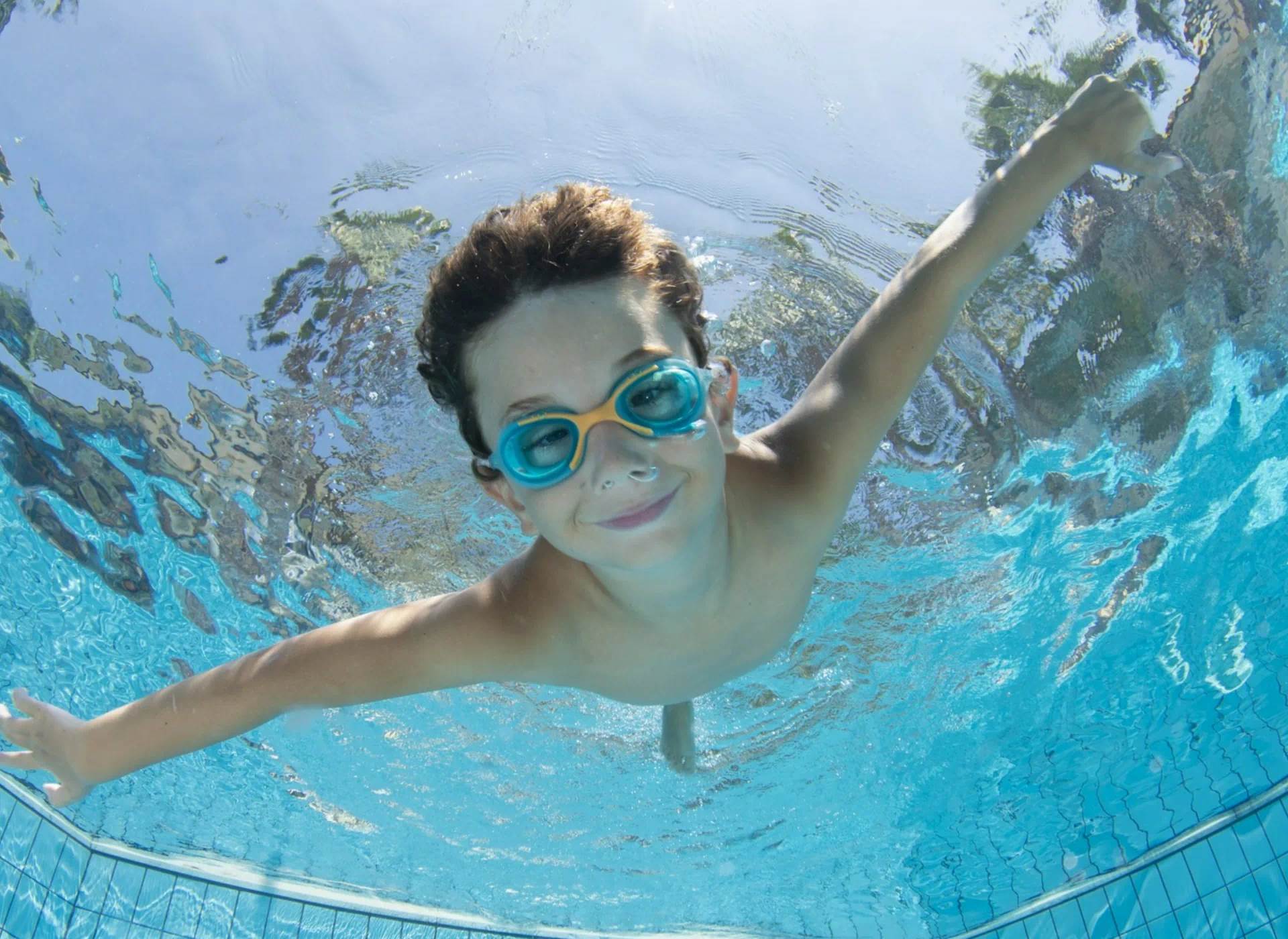 chłopiec w okularach pływacki zanurzony pod wodą