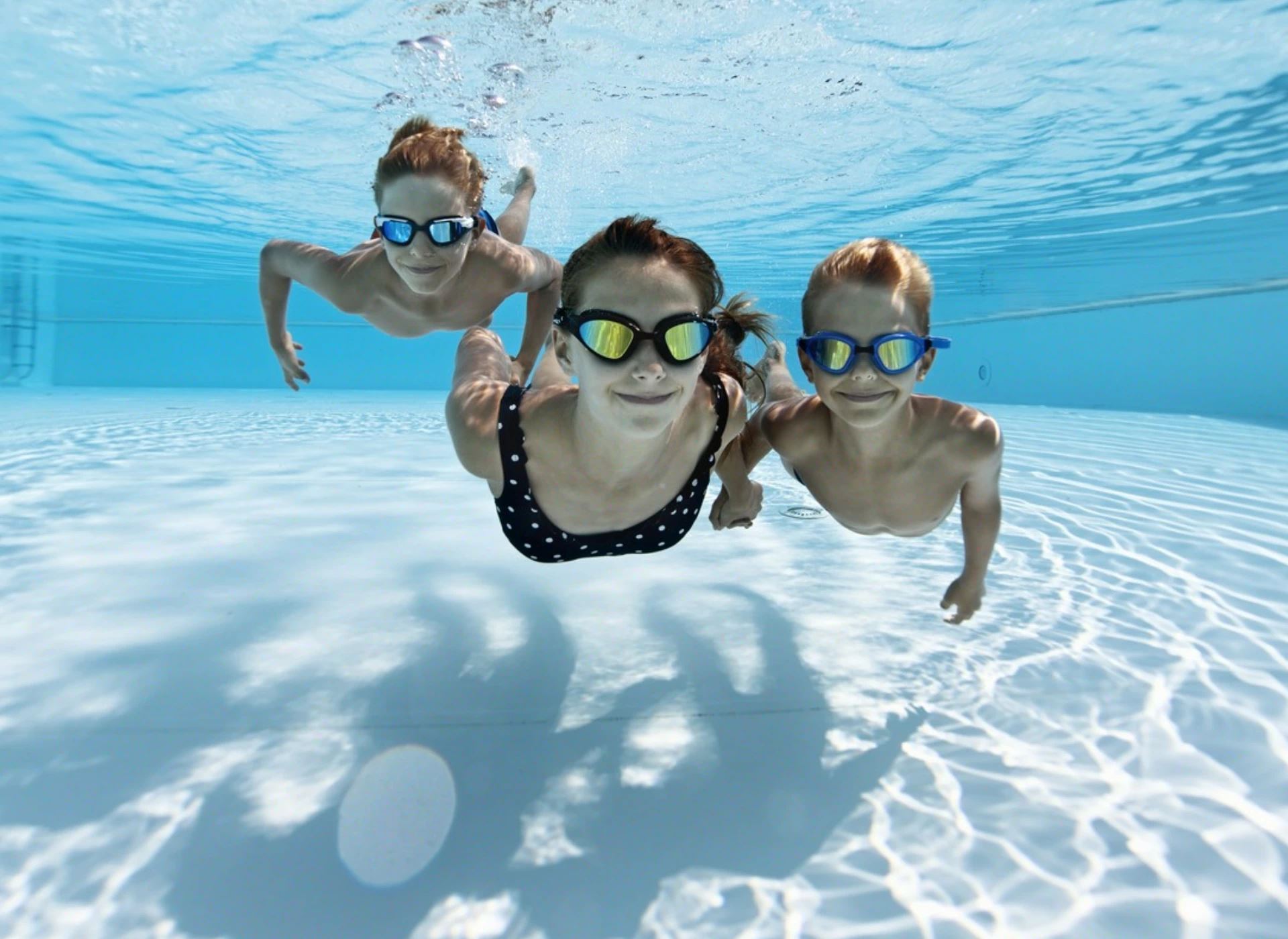 matka i dwójka dzieci płynąca pod wodą